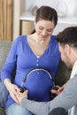 man holding headphones on pregnant womans belly Royalty Free Stock Photo