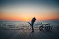 Man holding his girlfriend, couple of young lovers kissing at the beach at sunrise sky at wooden deck summer time Royalty Free Stock Photo