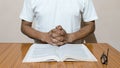 A man holding his hands on open holy book. Prayer concept