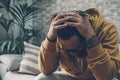 Man holding his head alone at home for desperation and stress emotions. Concept of tired adult and personal crisis. Sadness and Royalty Free Stock Photo