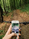 Man holding his smartphone capturing forest trail in spring. Royalty Free Stock Photo