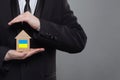 Man holding house with Ukrainian flag in his hands Royalty Free Stock Photo