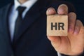 Man holding HR word on wooden cube