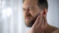 Man holding hurting ear, otitis or infection otolaryngologist problems, close up