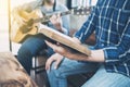 a man holding hymn books and sing a song while his friend playing guitar