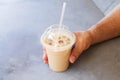 Man holding iced coffee or latte in take away plastic cup on street cafe Royalty Free Stock Photo