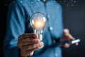 Man holding illuminated lightbulb glowing to Starting New idea, innovation and inspiration, smart intelligent creativity,