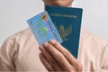 Man holding Indonesian Passport and Indonesian identity cards (KTP)