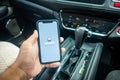 A man holding the iPhone X with Waze navigation app inside the car