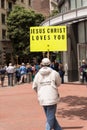 Man Holding Jesus Christ Loves You Sign in City