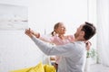 man holding joyful daughter and dancing