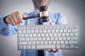 Man holding Judge gavel with computer keyboard. Concept of internet crime Royalty Free Stock Photo