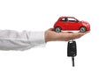 Man holding key and miniature automobile model on background, closeup. Car buying Royalty Free Stock Photo