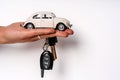 Man holding key and miniature automobile model on white background, closeup. Car buying Royalty Free Stock Photo