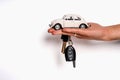 Man holding key and miniature automobile model on white background, closeup. Car buying Royalty Free Stock Photo