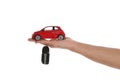 Man holding key and miniature automobile model on background, closeup. Car buying Royalty Free Stock Photo