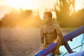 Man holding a kite in hands standing at the beach on sunset after a good kiteboarding session. Kitesurfer with wing