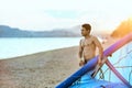 Man holding a kite in hands standing at the beach on sunset after a good kiteboarding session. Kitesurfer with wing