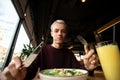 Man holding knife and fork while enjoying delicious food. Selfcare concept. Healthy food. Cheerful blonde man eating Royalty Free Stock Photo