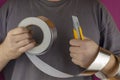 Man is holding a knife with interchangeable blades and aluminum tape