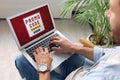 Man holding laptop with activated promo code indoors, closeup