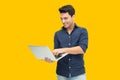 Man holding laptop computer isolated on yellow background, Feeling happiness, Caucasian Male model Royalty Free Stock Photo
