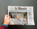 Man holding Le Monde Newspaper with Donald Trump