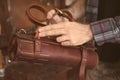 Man holding leather case for tools in workshop Royalty Free Stock Photo