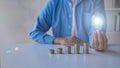 man holding light bulb on fire with pile of coins Calculator notebook on desk for saving energy, money concept Royalty Free Stock Photo