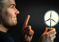 Man holding a light bulb with a wind turbine inside. Royalty Free Stock Photo