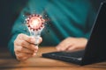 Man holding a light bulb while working on the computer to think and create new ideas. Royalty Free Stock Photo