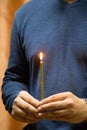 A man holding a lighted church candle Royalty Free Stock Photo