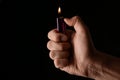 Man holding lighter on black background, closeup. Space for text Royalty Free Stock Photo