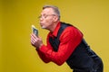 Man holding lots of dollar bills in hands, isolated on yellow background Royalty Free Stock Photo