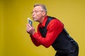 Man holding lots of dollar bills in hands, isolated on yellow background. Happy man enjoying money Royalty Free Stock Photo