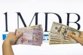 Man holding Malaysia Ringgit with burr 1MDB background indicating the US Government inves Royalty Free Stock Photo