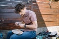 Man holding marker and template over skateboard deck in his lap Royalty Free Stock Photo