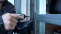 A man holding a metal profile with a riveting tool.