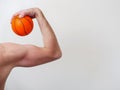 Man holding mini basketball in his hand and flexing his mussels