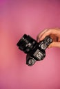 A man holding a mirrorless camera in his hands on a light background top view. photographer adjusts the camera close-up. Royalty Free Stock Photo