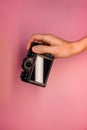 A man holding a mirrorless camera in his hands on a light background top view. photographer adjusts the camera close-up.