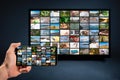 Man holding mobile phone with many icons of video service on demand on background Online TV VOD provider. Interface video Royalty Free Stock Photo