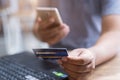 Man holding mock up credit card with number using smartphone and laptop computer for shopping.Shopping and payment online. Royalty Free Stock Photo