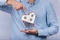 Man holding model home in shopping cart. Buying house concept Royalty Free Stock Photo