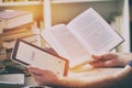 Man holding a modern ebook reader and book in library Royalty Free Stock Photo