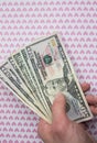Man is holding money in hand on the background with pink hearts. Loving dollars. Time to go shopping and buy things. Money