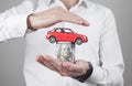 Man holding money and red toy car Royalty Free Stock Photo