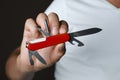 Man holding multitool on dark background, closeup Royalty Free Stock Photo