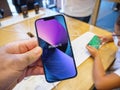 Man holding new iPhone 13 at the Apple Store with its colorful wallpaper