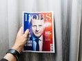 Man holding newspaper with Emmanuel Macron on first page cover